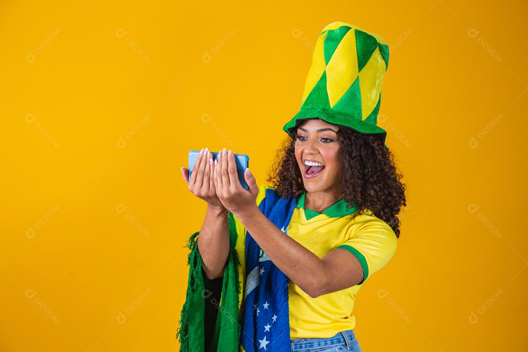 Garota afro torcendo pelo time brasileiro, segurando bandeira nacional