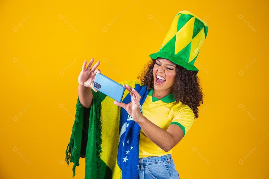 Garota afro torcendo pelo time brasileiro, segurando bandeira nacional