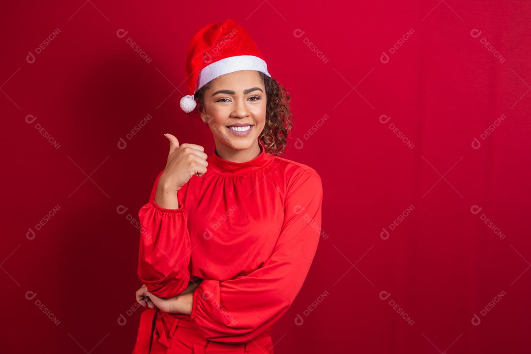 Mulher afro com polegar para cima fazendo polegares para cima com roupa de natal.