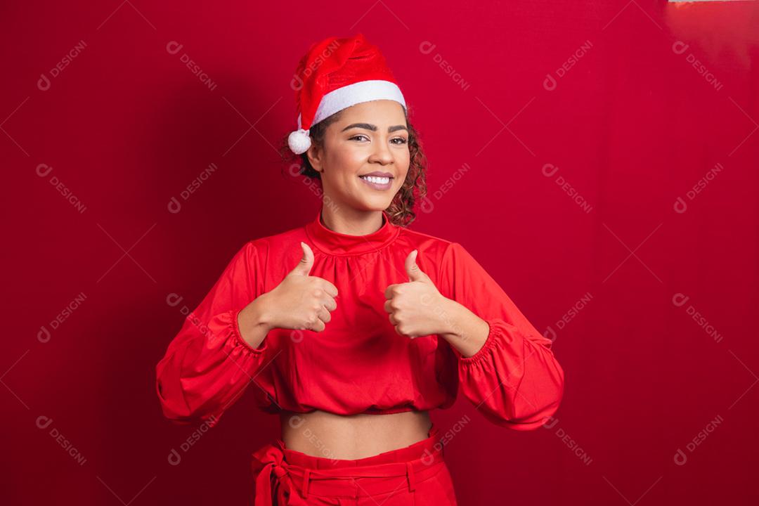 Sorridente jovem afro com chapéu de natal segurando um coração enorme