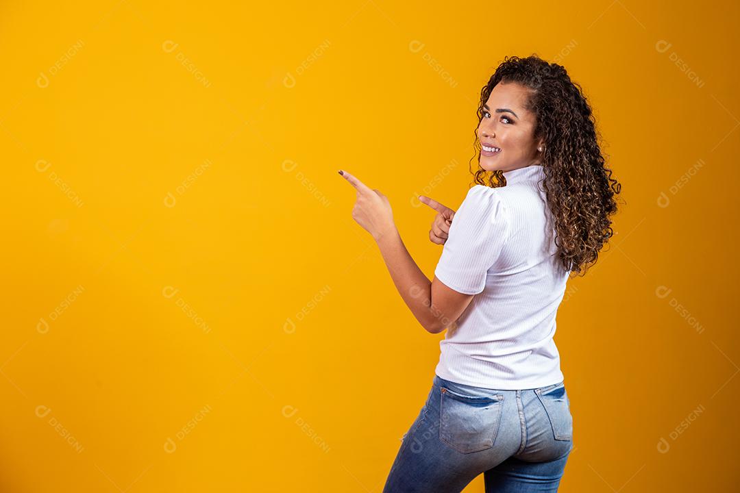 Mulher Alegre apontando para lugar vazio