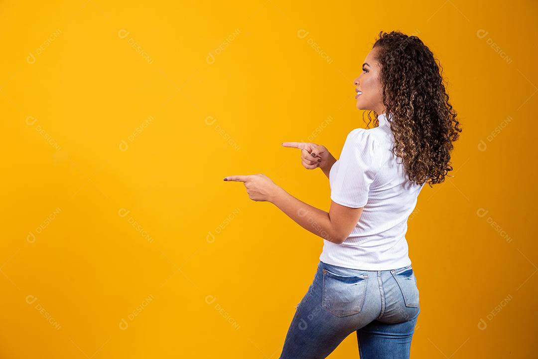 Mulher Alegre apontando para lugar vazio