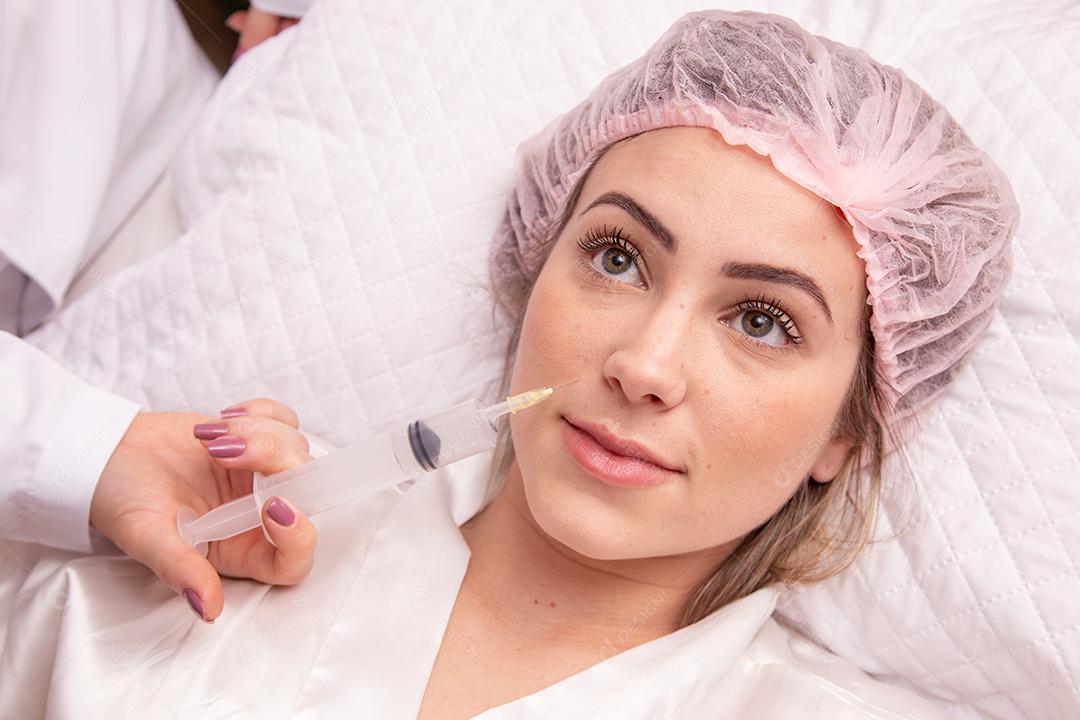 Closeup de mulher aplicando ozônio no rosto para tratamento cosmético