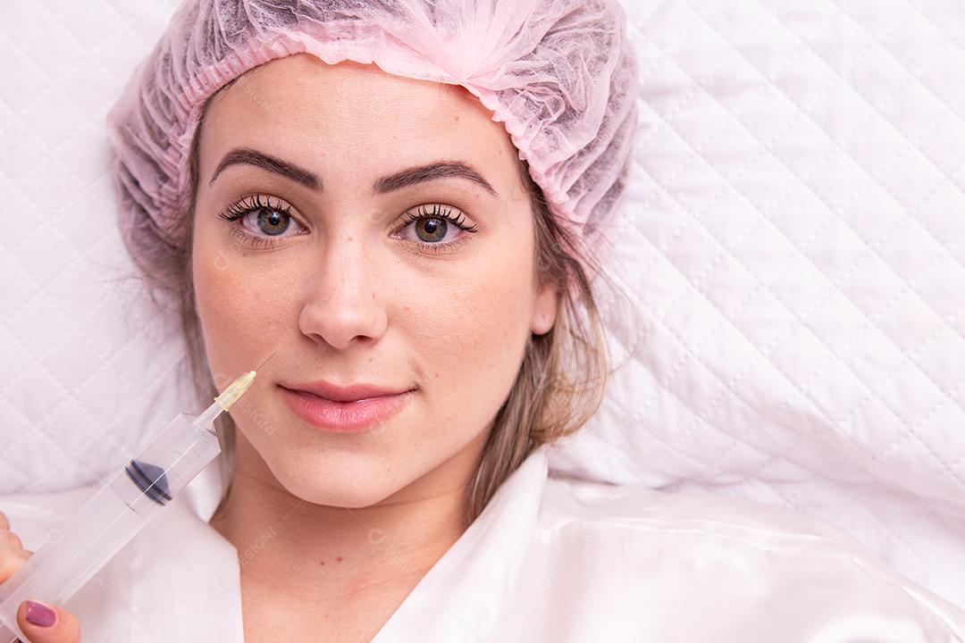 Closeup de mulher aplicando ozônio no rosto para tratamento cosmético