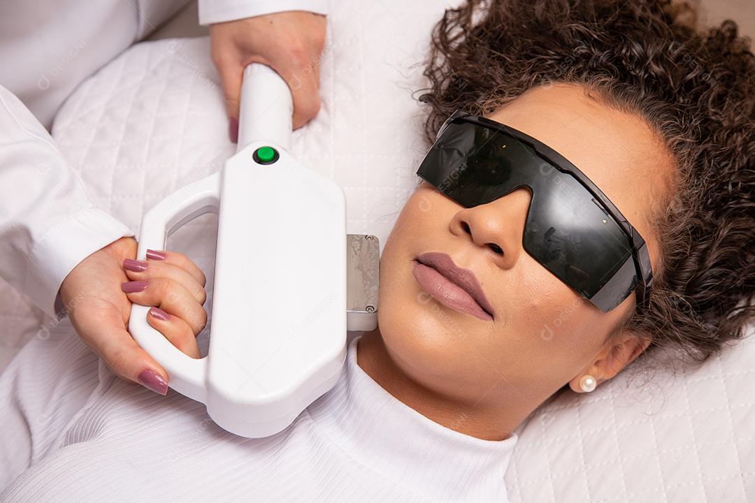 Mulher afro no salão de beleza profissional fazendo depilação a laser