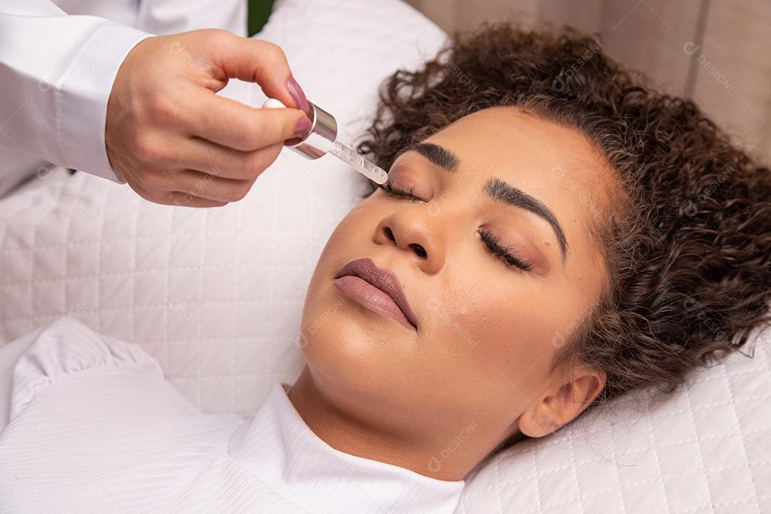 Rosto feminino de close-up com dermaroller para procedimentos de mesoterapia