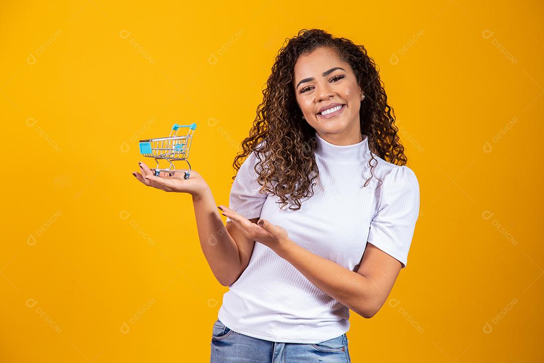 Mulher com pequeno carrinho de compras Sorrindo