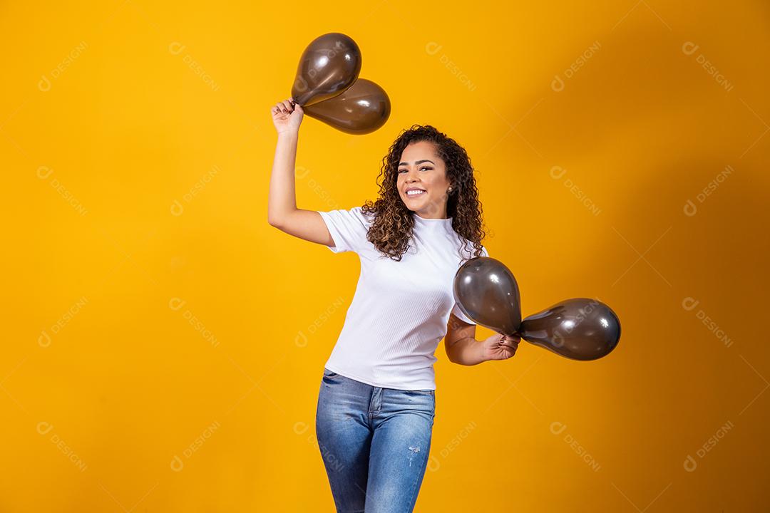 Mulher afro com balões pretos comemorando ofertas de aniversário