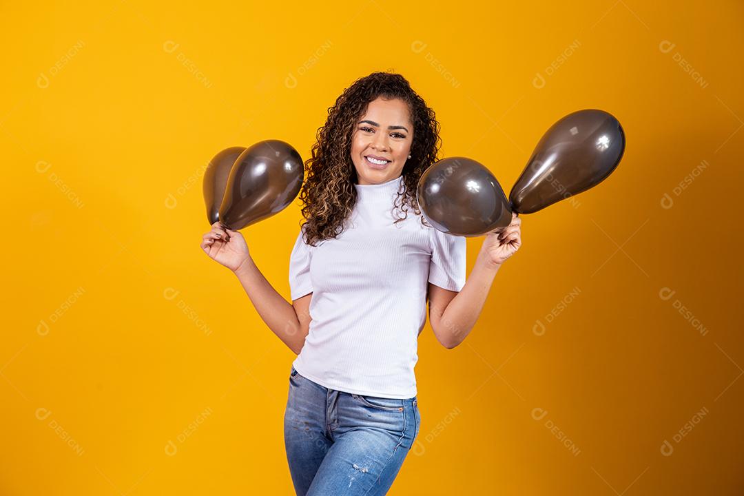 Mulher afro com balões pretos comemorando ofertas de aniversário