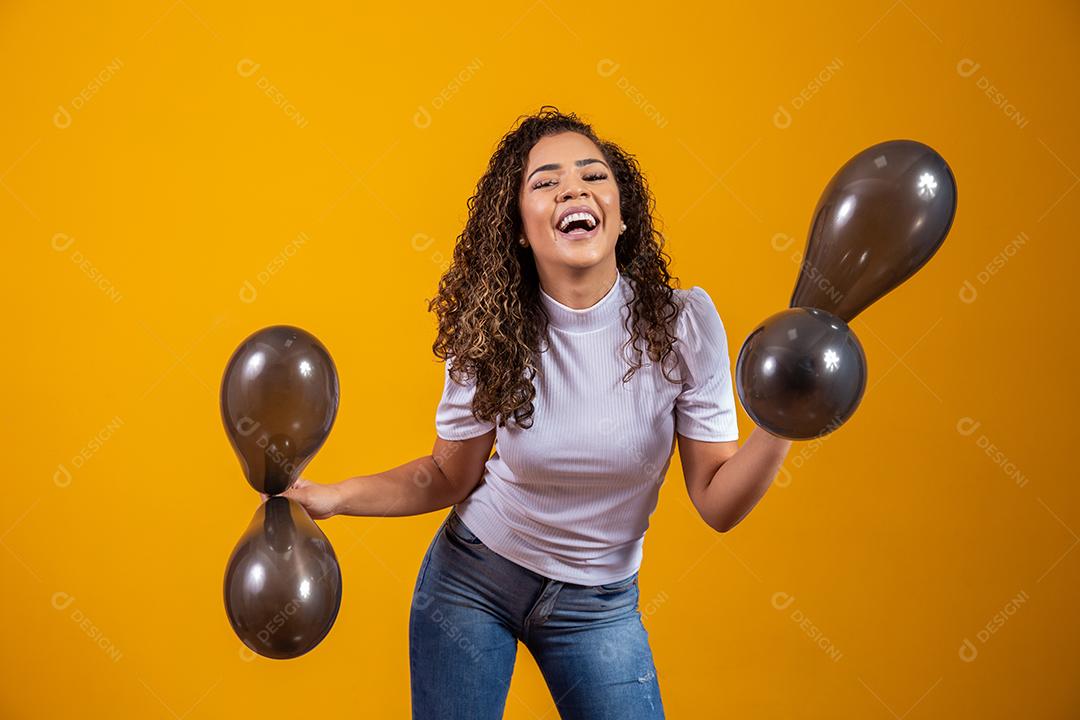 Mulher afro com balões pretos comemorando ofertas de aniversário