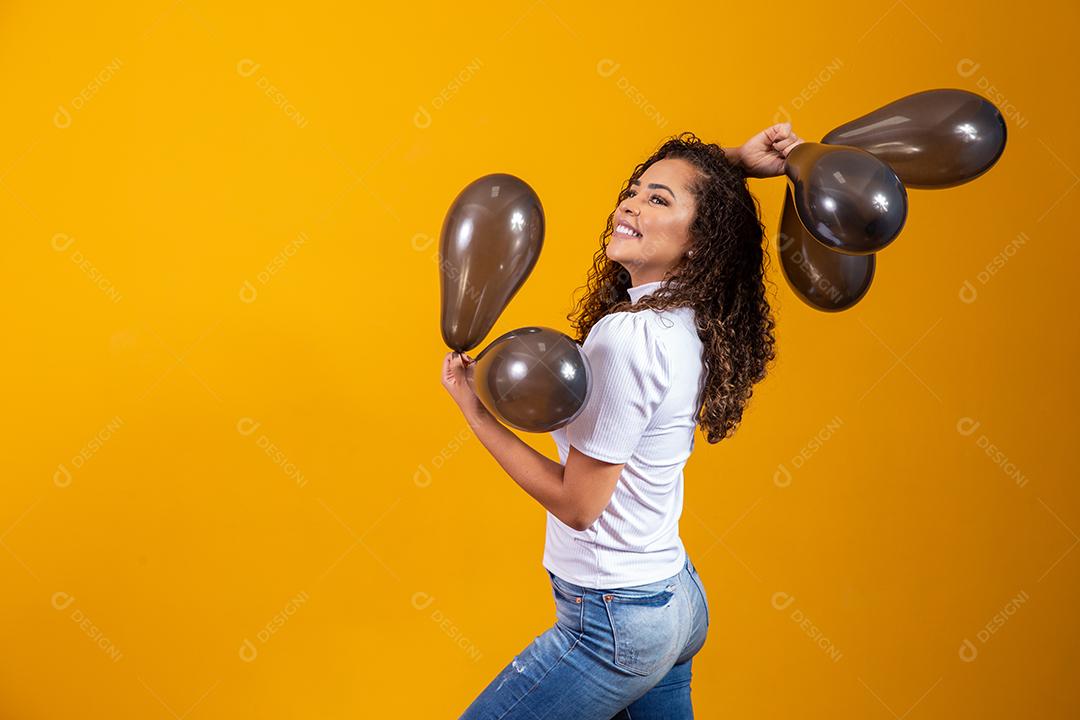 Mulher afro com balões pretos comemorando ofertas de aniversário