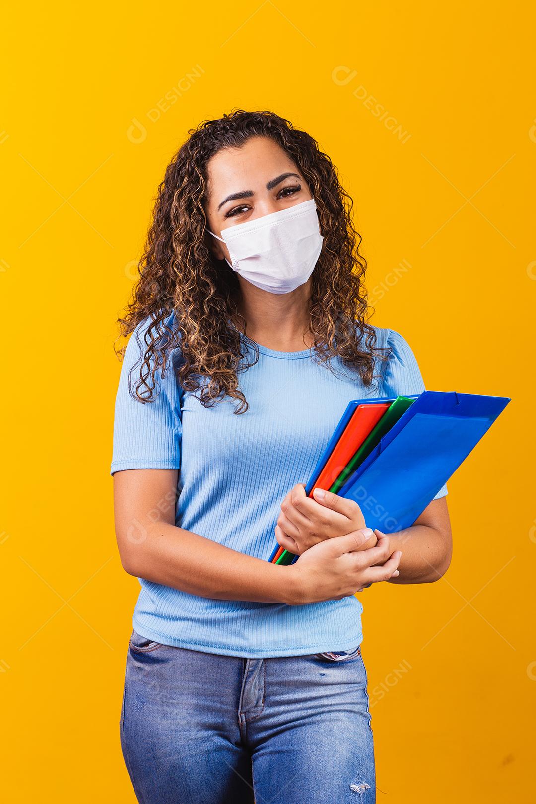 linda mulher cabelo cacheado usando mascara segurando material escola fotos imagem