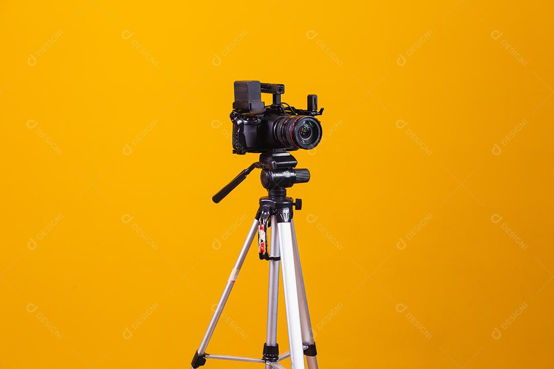 tripé câmera cinematográfica em fundo amarelo