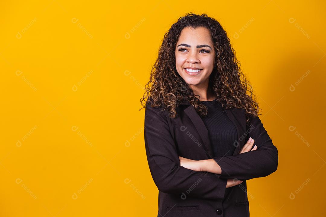 Mulher de negócios afro. Mulher negra confiante de terno posando com braços cruzados sobre fundo amarelo, faixa horizontal