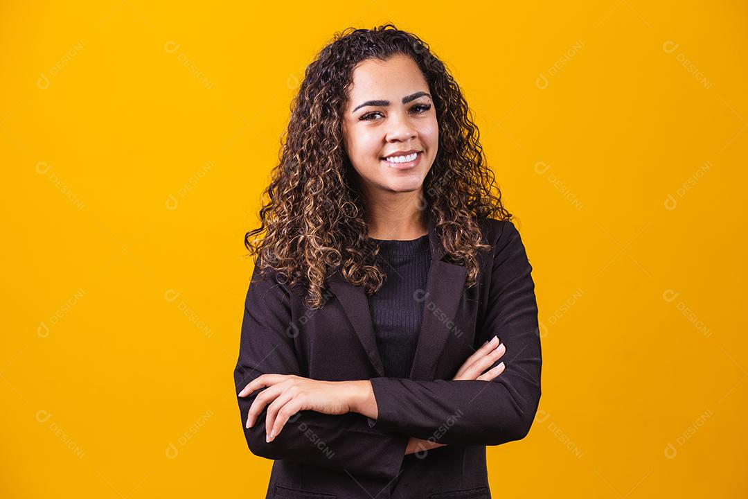 Mulher de negócios afro. Mulher negra confiante de terno posando com braços cruzados sobre fundo amarelo, faixa horizontal