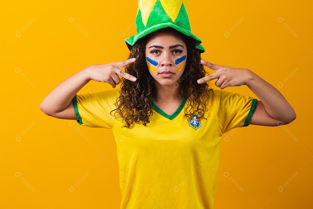 Fã brasileiro. Usando tinta como maquiagem, fã comemorando o jogo de futebol ou futebol