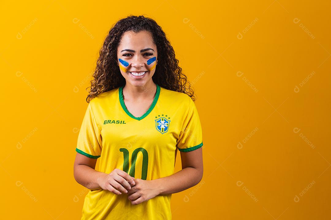 torcedor brasileiro. Fã de mulher brasileira comemorando no futebol ou partida de futebol em fundo amarelo. Cores do Brasil. Sim!