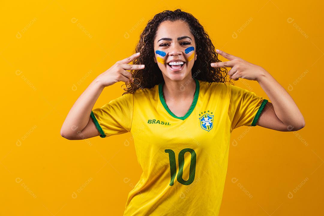 torcedor brasileiro. Fã de mulher brasileira comemorando no futebol ou partida de futebol em fundo amarelo. Cores do Brasil. Sim!