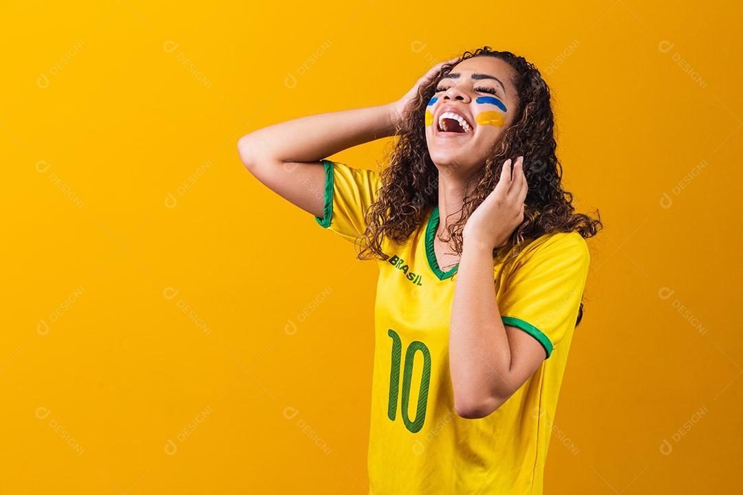 torcedor brasileiro. Fã de mulher brasileira comemorando no futebol ou partida de futebol em fundo amarelo. Cores do Brasil. Sim!