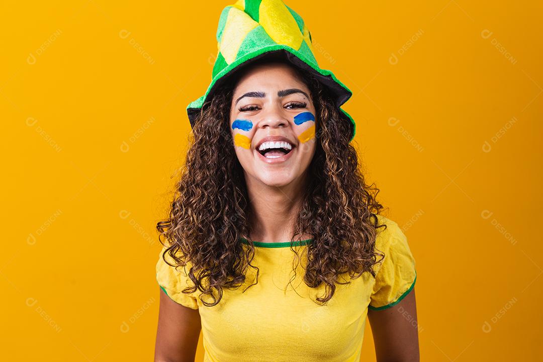 torcedor brasileiro. Fã de mulher brasileira comemorando no futebol ou partida de futebol em fundo amarelo. Cores do Brasil. Sim!