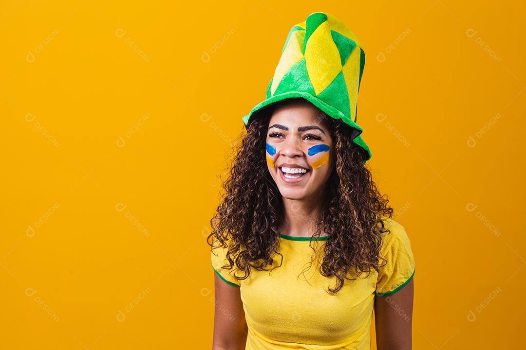 torcedor brasileiro. Fã de mulher brasileira comemorando no futebol ou partida de futebol em fundo amarelo. Cores do Brasil. Sim!