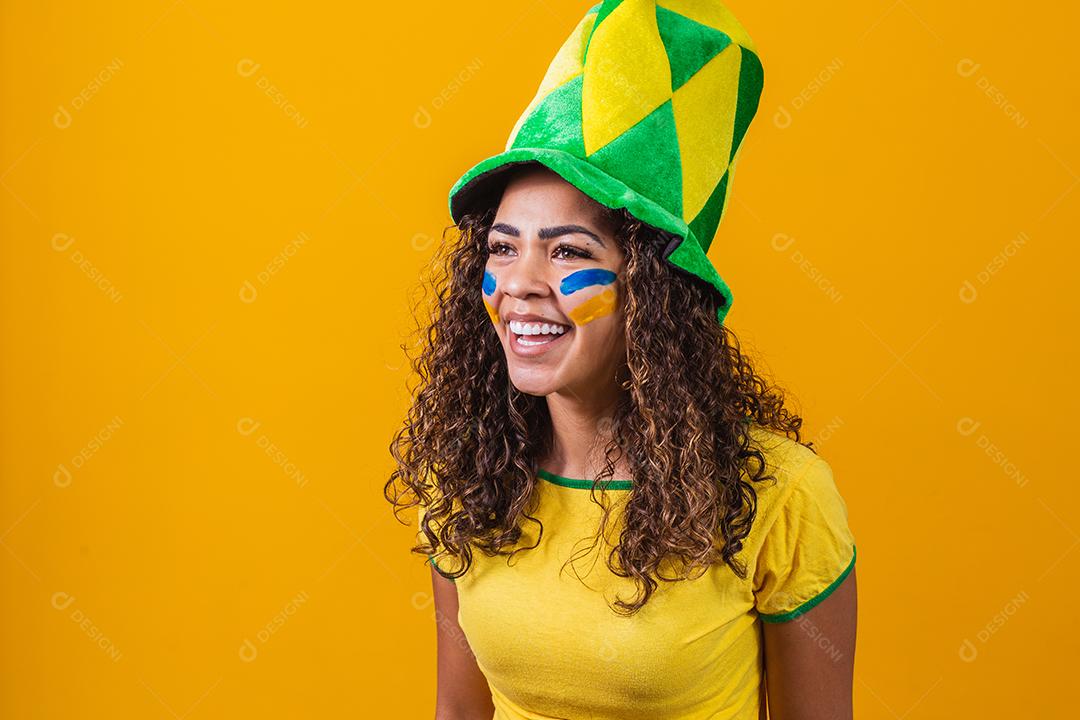 torcedor brasileiro. Fã de mulher brasileira comemorando no futebol ou partida de futebol em fundo amarelo. Cores do Brasil. Sim!