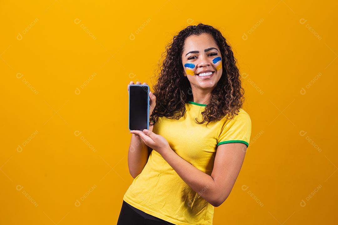 fã brasileiro segurando um smartphone