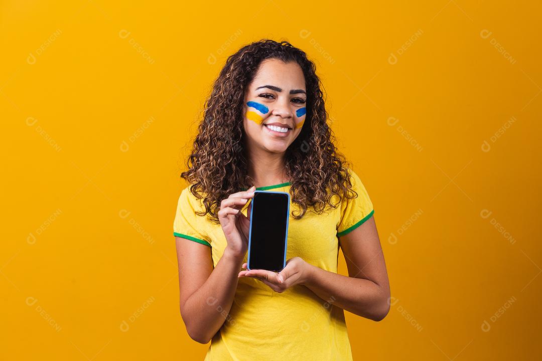 fã brasileiro segurando um smartphone