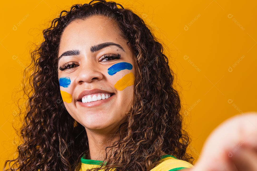 fã brasileira com o rosto pintado de azul e amarelo