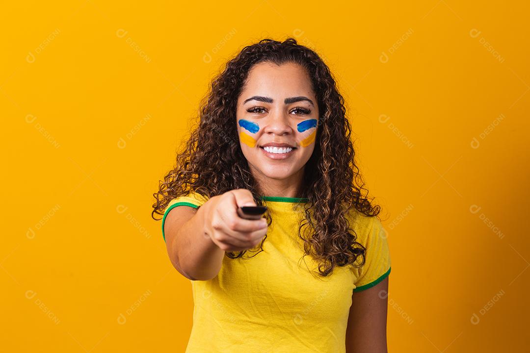 Jovem fã brasileira com controlador na mão pronta para assistir ao jogo brasileiro