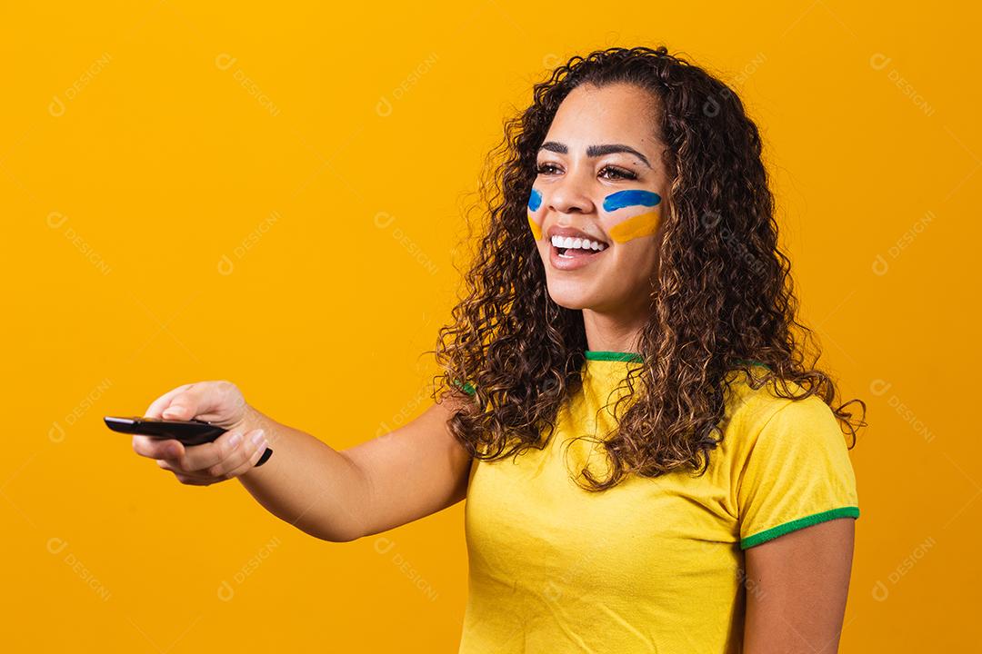 Jovem fã brasileira com controlador na mão pronta para assistir ao jogo brasileiro