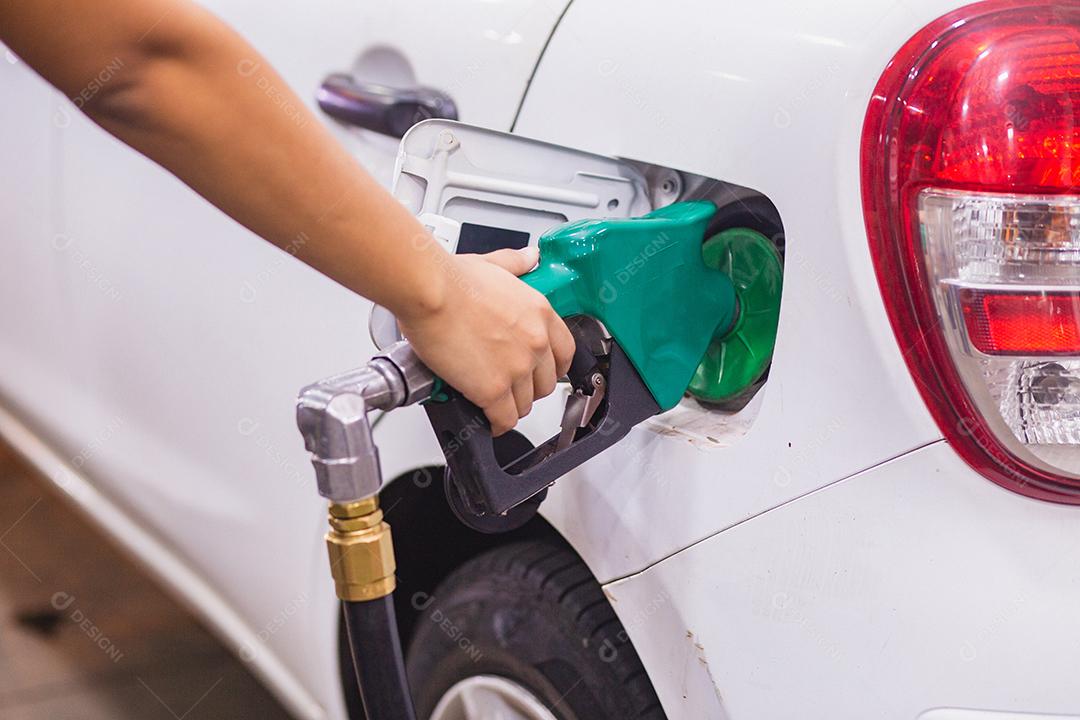 Reabastecimento do carro com gasolina no posto de gasolina e bocal de combustível de enchimento da bomba de gasolina no tanque de combustível do carro