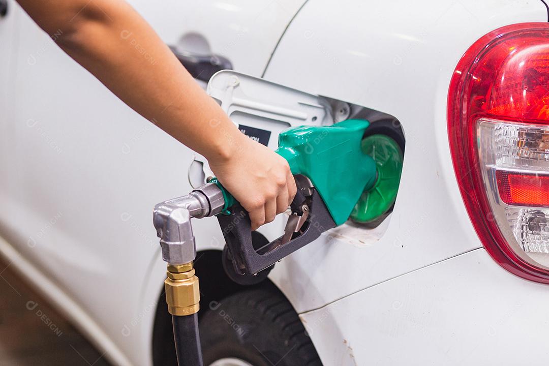 Reabastecimento do carro com gasolina no posto de gasolina e bocal de combustível de enchimento da bomba de gasolina no tanque de combustível do carro