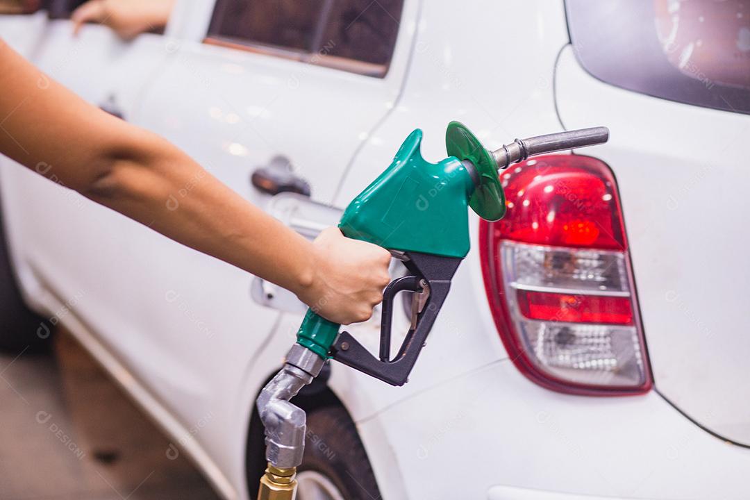 Reabastecimento do carro com gasolina no posto de gasolina e bocal de combustível de enchimento da bomba de gasolina no tanque de combustível do carro