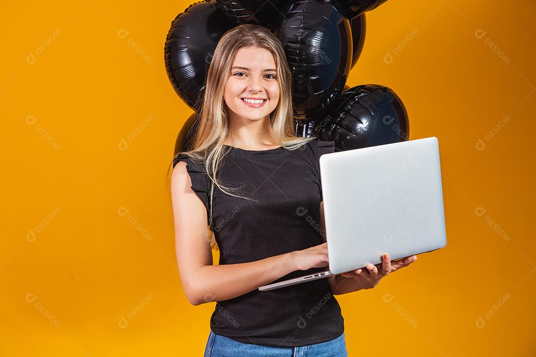 Sorrindo alegre e engraçada morena jovem 20 anos usando computador portátil pc em fundo de cor amarela brilhante