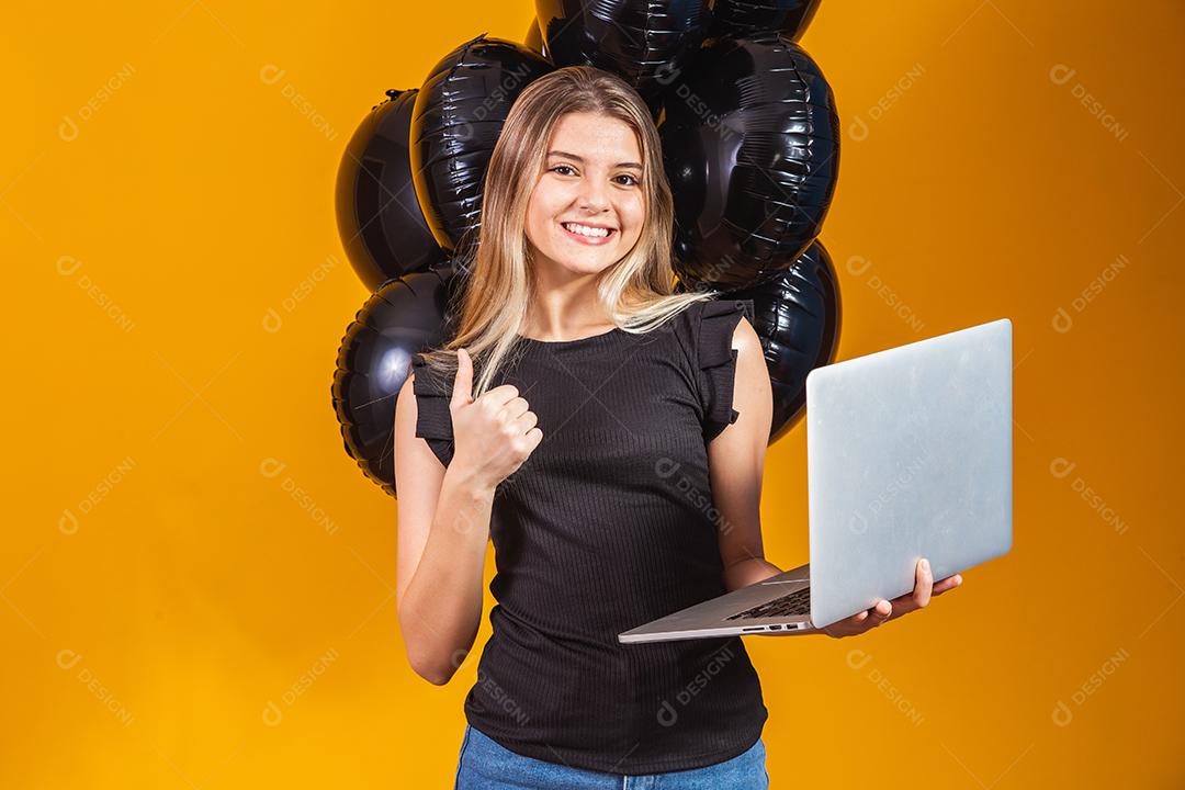Sorrindo alegre e engraçada morena jovem 20 anos usando computador portátil pc em fundo de cor amarela brilhante