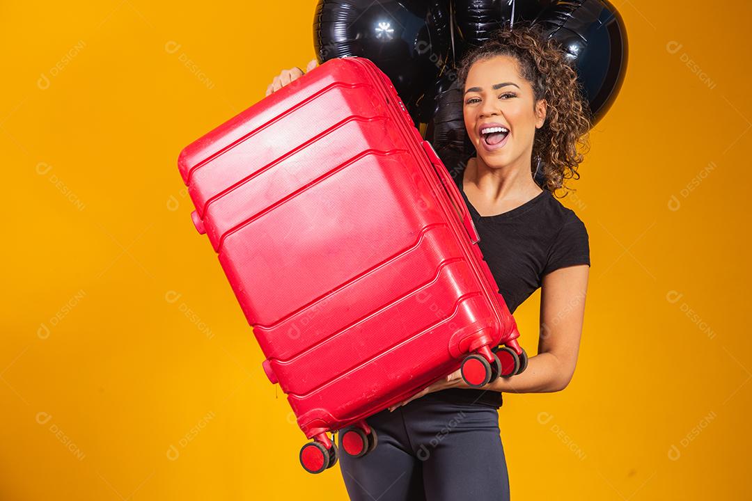 Mulher engraçada segurando uma mala de viagem pesada. Aniversário de promoção de viagens. Black Friday em bilhetes de viagem.