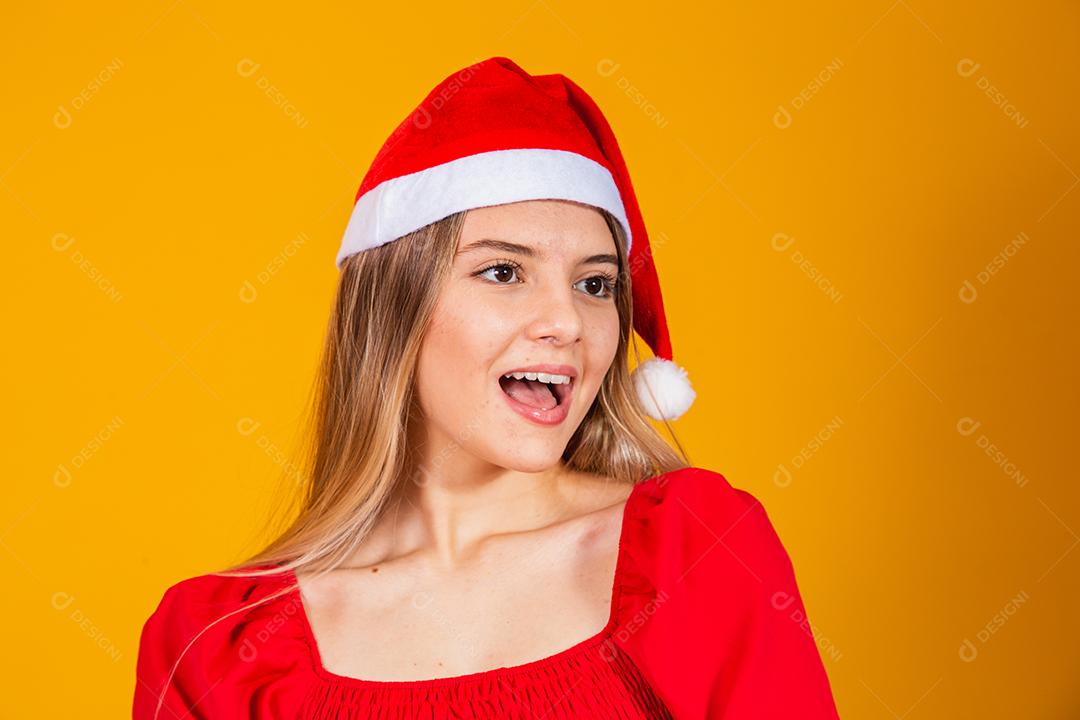 Jovem mulher bonita sobre fundo isolado com cara feliz de chapéu de Natal sorrindo com os braços cruzados, olhando para a câmera. Pessoa positiva.