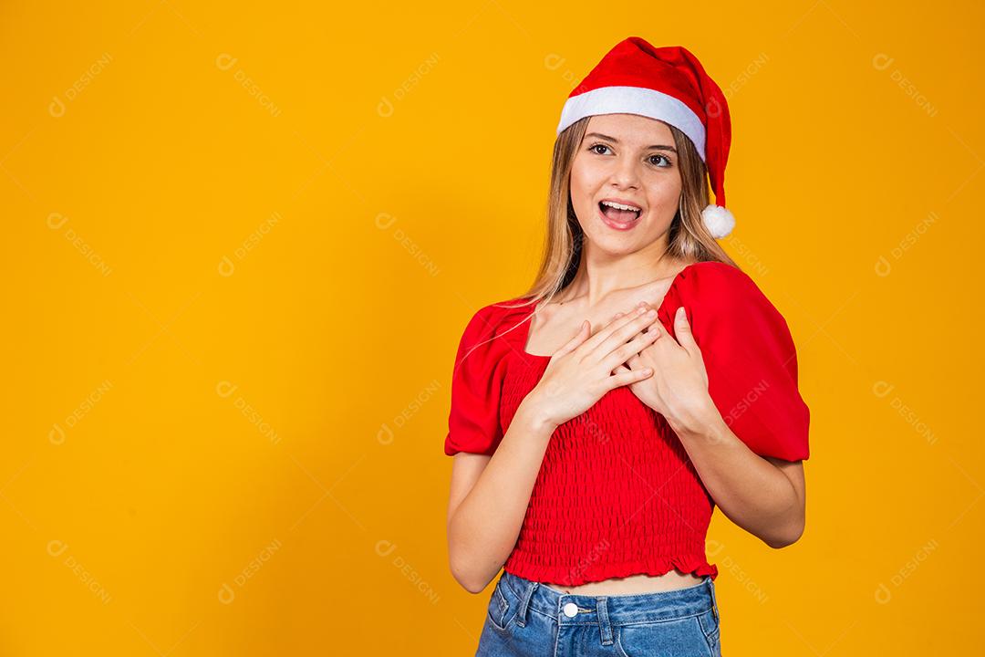 Jovem mulher bonita sobre fundo isolado com cara feliz de chapéu de Natal sorrindo com os braços cruzados, olhando para a câmera. Pessoa positiva.