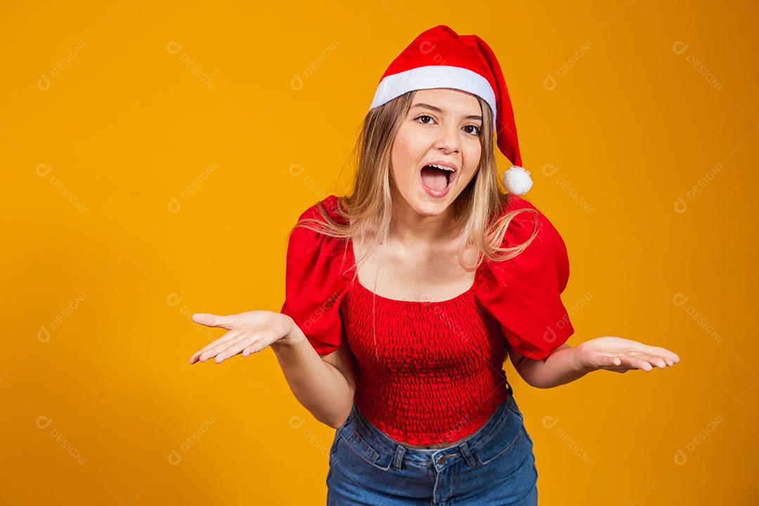 Imagem de jovem gritando animado em pé isolado sobre fundo amarelo com chapéu de Papai Noel