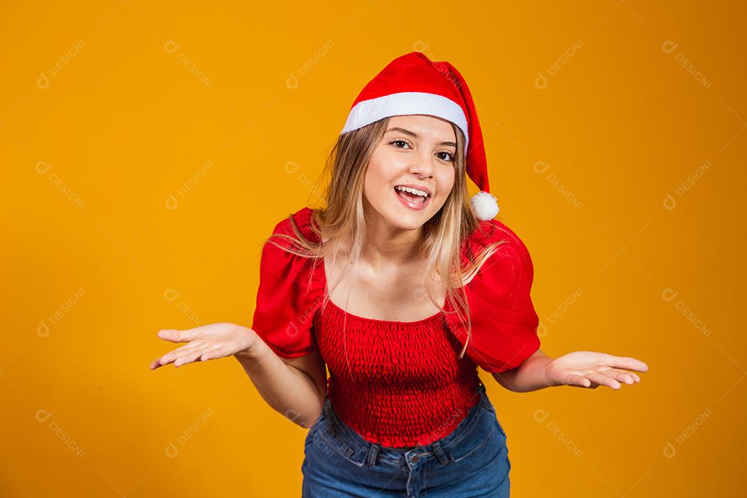 Imagem de jovem gritando animado em pé isolado sobre fundo amarelo com chapéu de Papai Noel