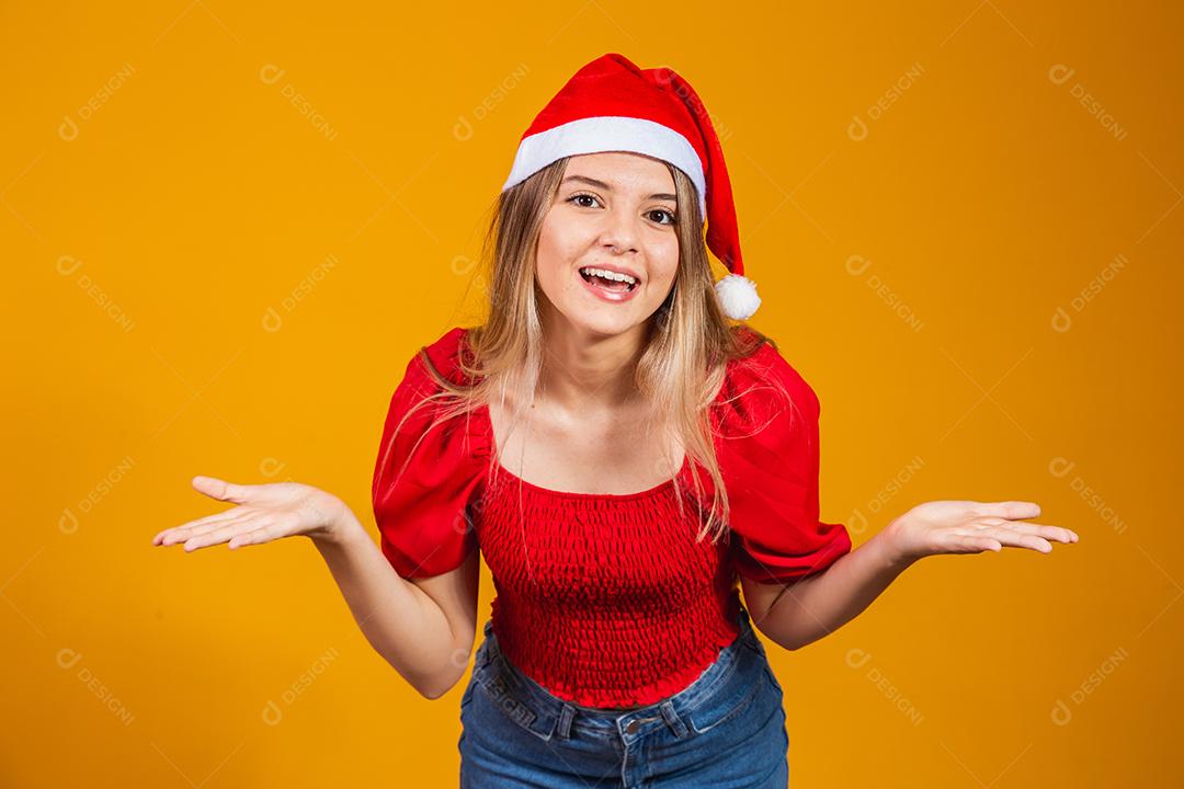 Imagem de jovem gritando animado em pé isolado sobre fundo amarelo com chapéu de Papai Noel