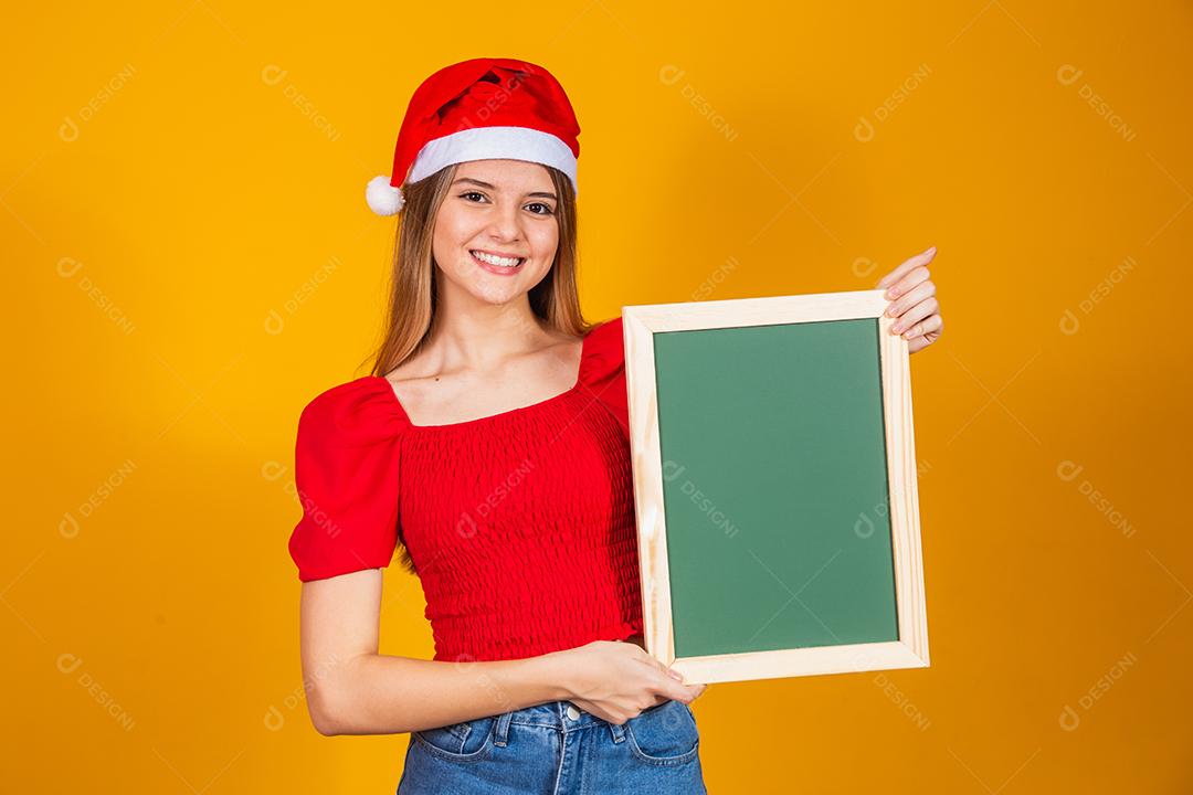 jovem loira vestida para o natal segurando um cartaz. Natal