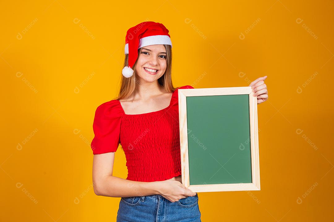 jovem loira vestida para o natal segurando um cartaz. Natal