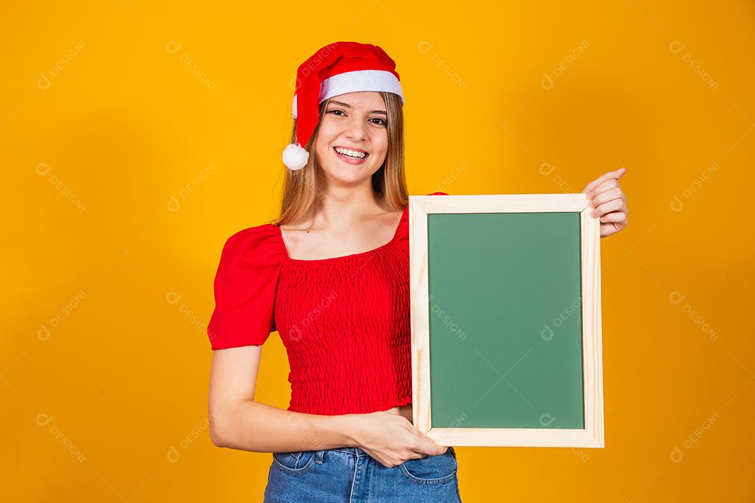 jovem loira vestida para o natal segurando um cartaz. Natal