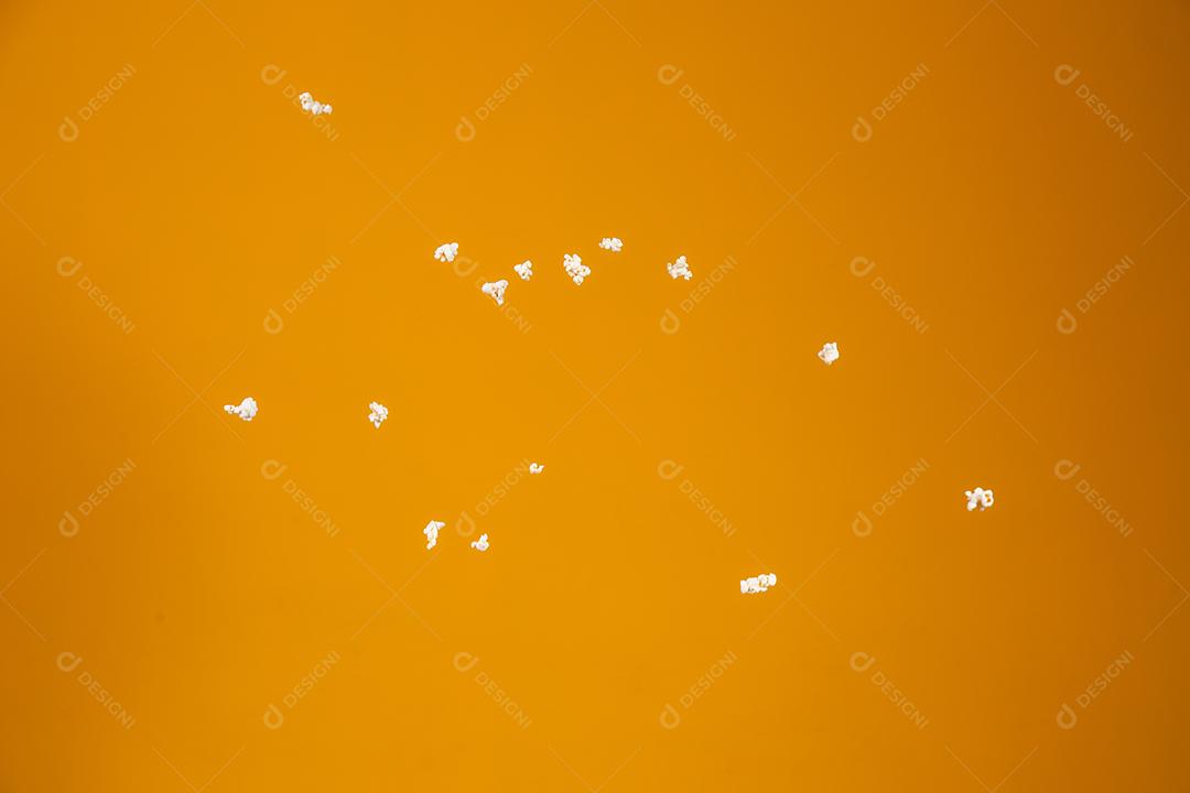 Imagem pipocas voando flutuando em fundo amarelo
