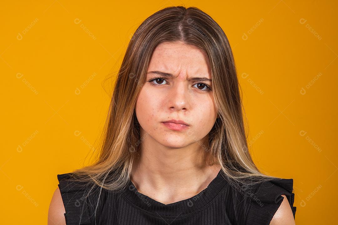 Mulher Com roupa preta e língua para fora com raiva em fundo amarelo