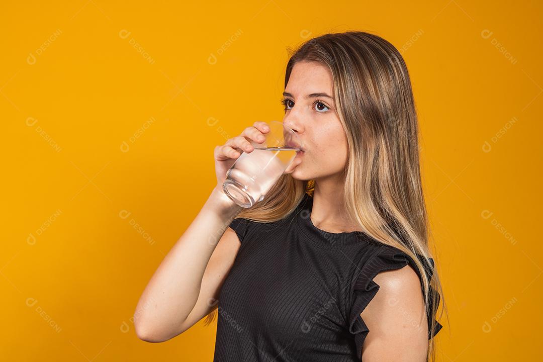 young blonde hydrating herself by drinking water