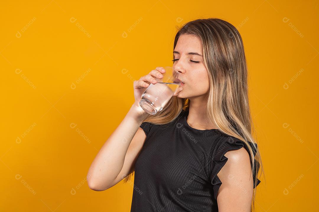 jovem loira se hidratando bebendo água