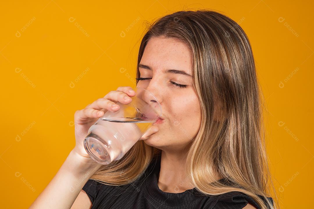 jovem loira se hidratando bebendo água